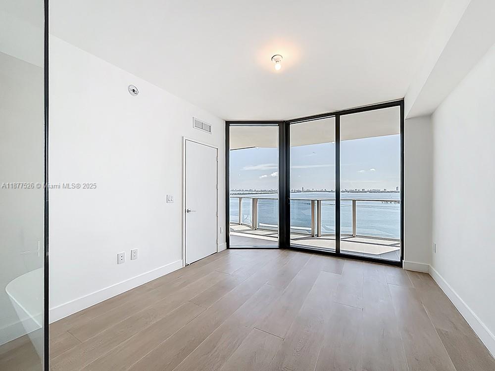 700 Northeast 24th Street, Unit 1402 Miami, FL 33137 - Photo 10 of 68 wooden floor in an empty room with a window