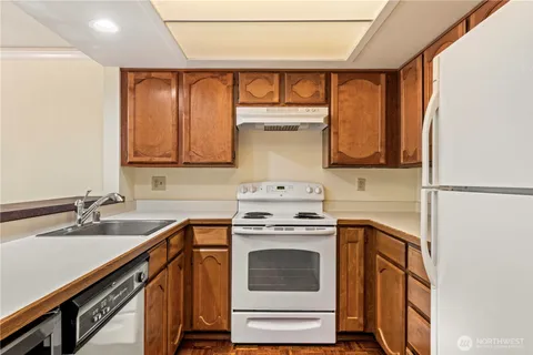 a kitchen with a sink cabinets appliances and a window