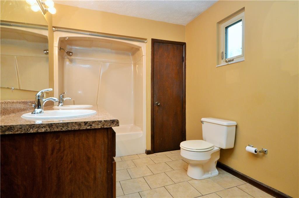 1023-1025 Moon Run Road McKees Rocks, PA 15136 - Photo 18 of 25 a bathroom with a granite countertop sink toilet and a mirror