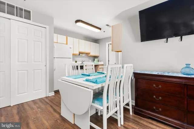 a kitchen with stainless steel appliances kitchen island granite countertop a table and a flat screen tv