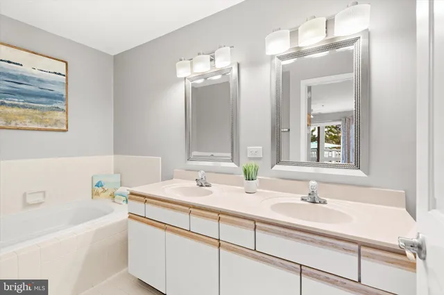 a bathroom with a sink double vanity granite tub and a mirror