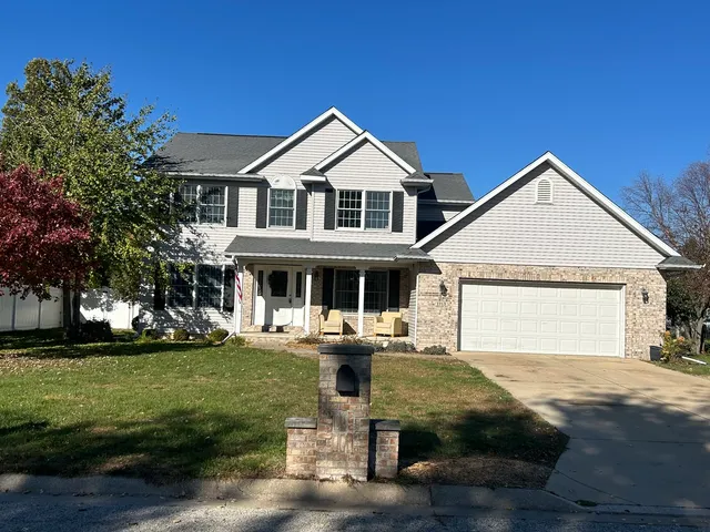 a front view of a house with a garden and plants
