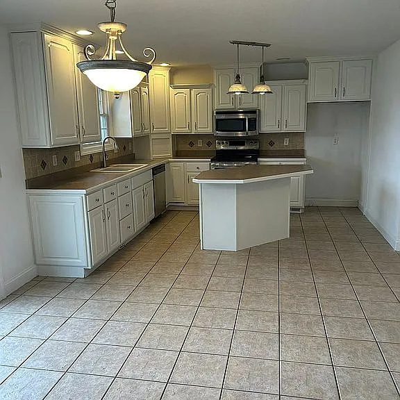 1713 Bob O Link Street Pontiac, IL 61764 - Photo 3 of 17 a kitchen with stainless steel appliances a sink a stove a refrigerator cabinets and a dining table