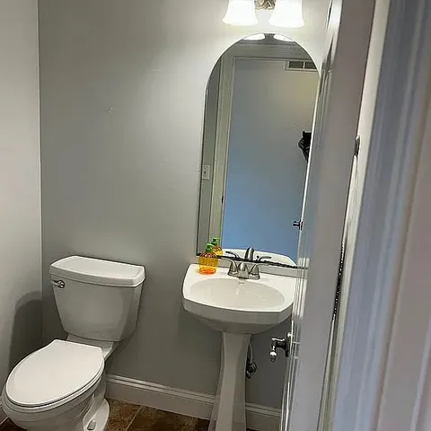 a bathroom with a toilet sink and mirror