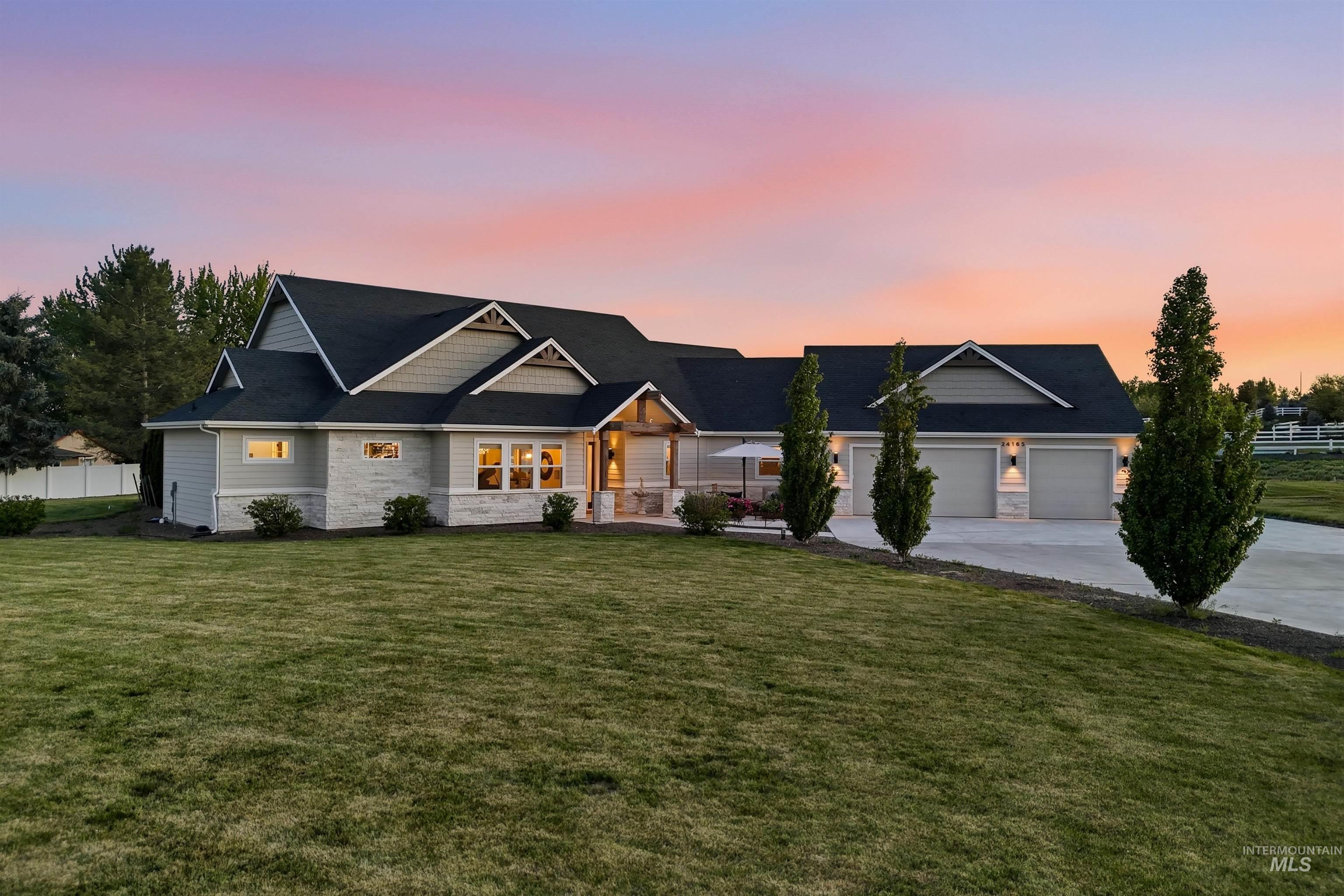 24165 Boer Goat Avenue Caldwell, ID 83607 - Photo 1 of 34 Contemporary residence with a multi-gabled roofline and a combination of light gray siding and stone veneer