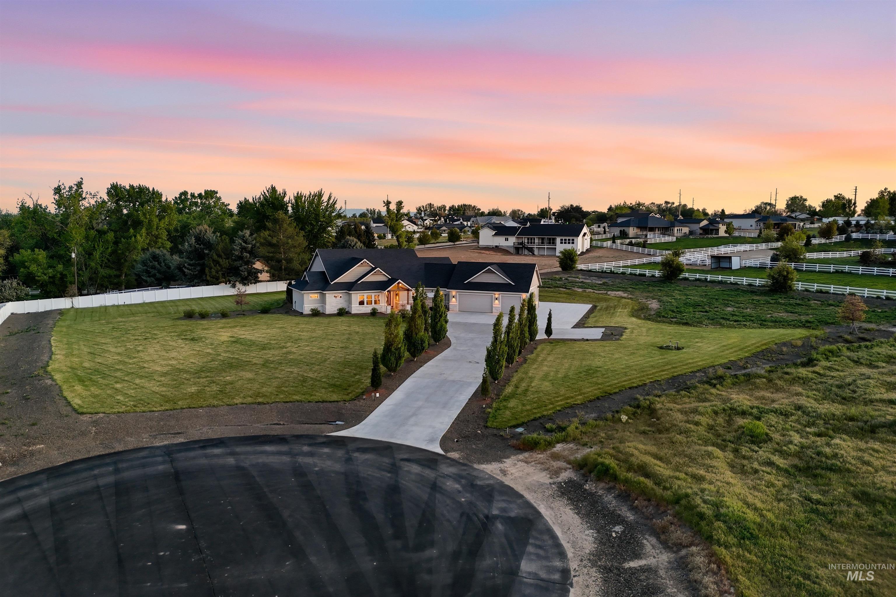 24165 Boer Goat Avenue Caldwell, ID 83607 - Photo 2 of 34 Modern ranch-style home featuring a dark shingle roof, light-colored siding, and a prominent concrete driveway