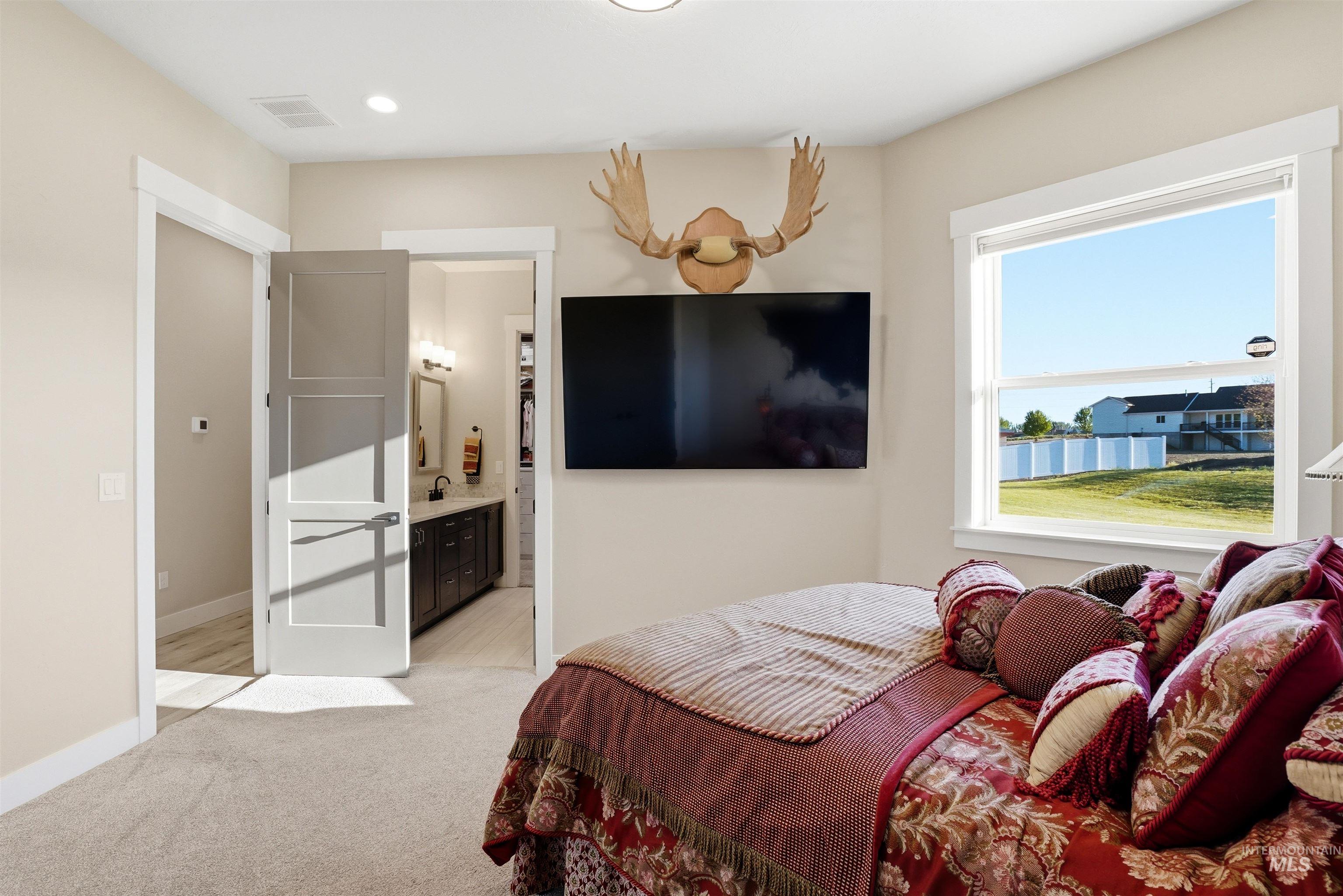 24165 Boer Goat Avenue Caldwell, ID 83607 - Photo 21 of 34 Carpeted room featuring a large window, recessed lighting, and a neutral wall color