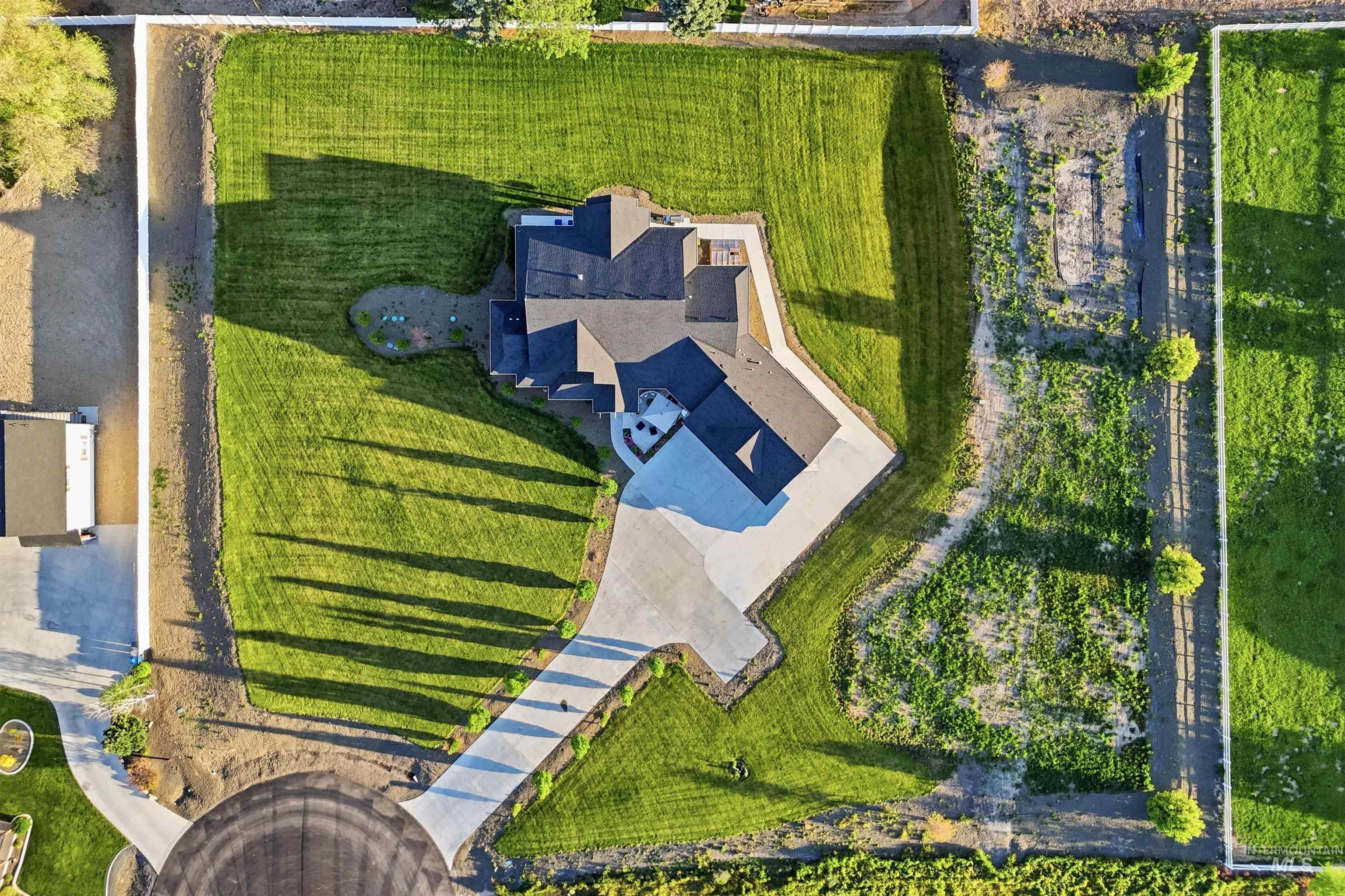 24165 Boer Goat Avenue Caldwell, ID 83607 - Photo 25 of 34 Expansive property featuring a large residence with a dark roof and a paved driveway
