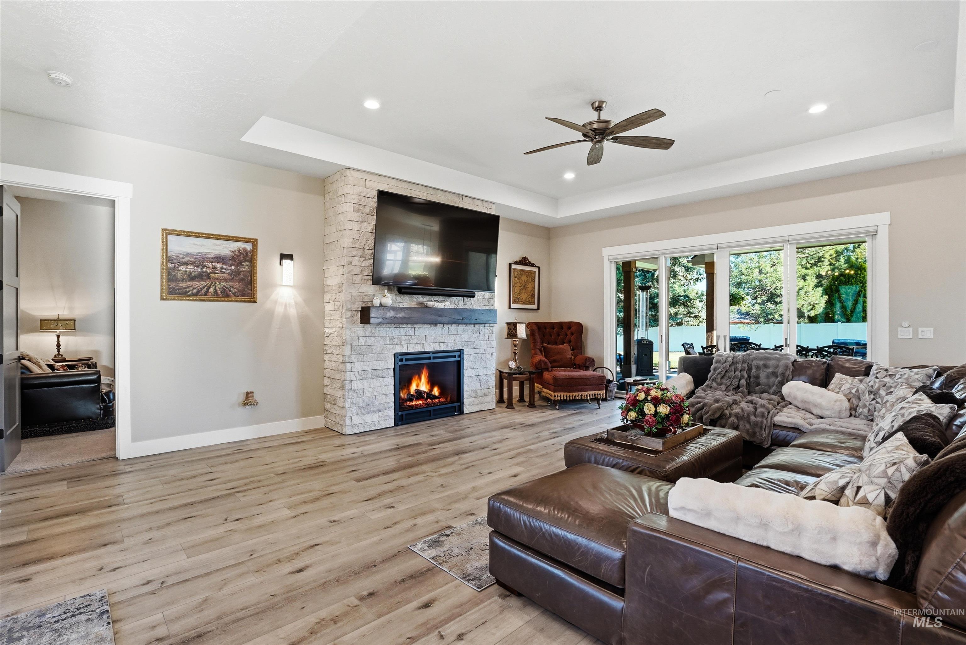24165 Boer Goat Avenue Caldwell, ID 83607 - Photo 6 of 34 Living area featuring a stone-clad fireplace with a wood mantel, wood-finish flooring, and recessed lighting