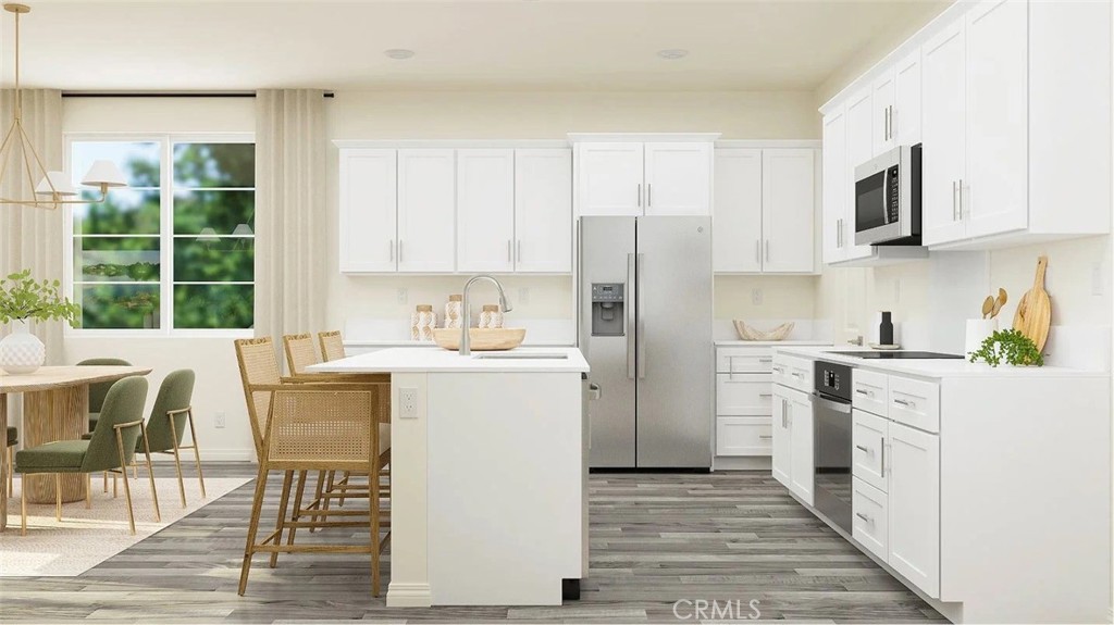 1707 Eagle Road Rialto, CA 92376 - Photo 3 of 18 a kitchen with a refrigerator a stove top oven a sink dishwasher and white cabinets with wooden floor