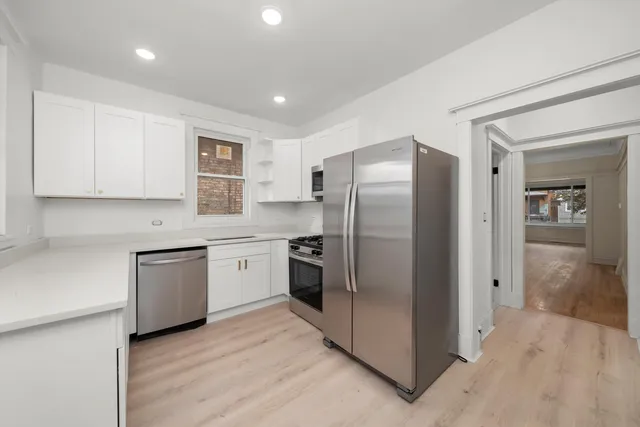 a kitchen with a refrigerator sink and white cabinets