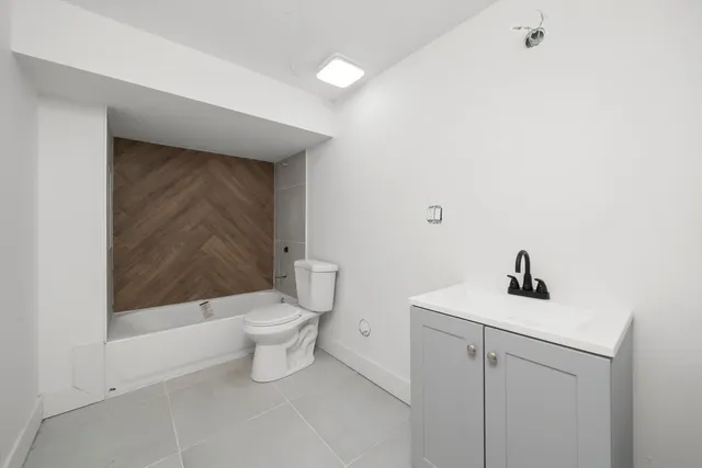 a bathroom with a toilet a sink and mirror