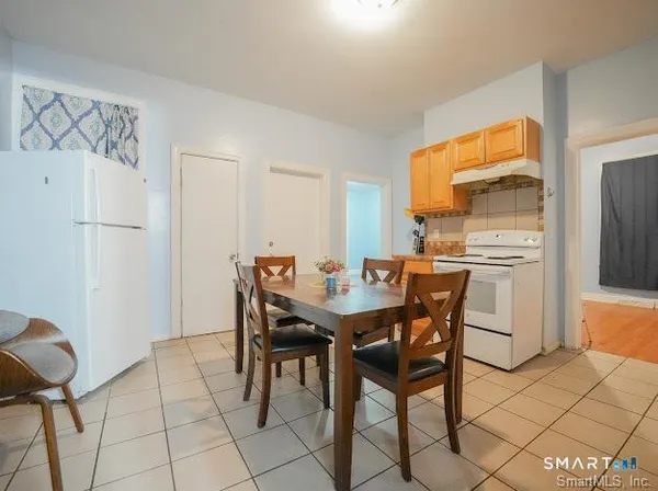 a dining room with furniture and a refrigerator