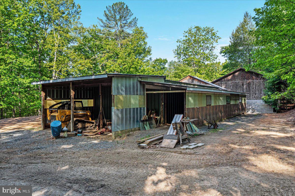 146 Lizzie Mills Road Castleton, VA 22716 - Photo 72 of 91 a view of a barn with table and chairs under an umbrella