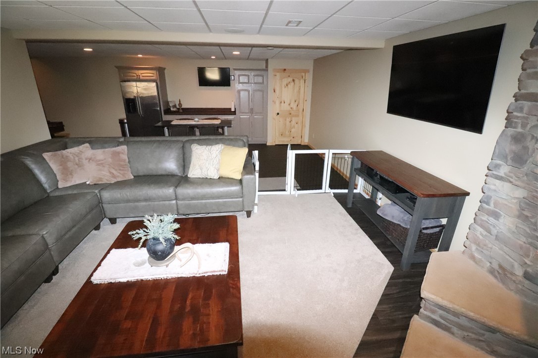 10582 Irvin Road Creston, OH 44217 - Photo 35 of 47 Living room in basement with a paneled ceiling and dark wood-type flooring