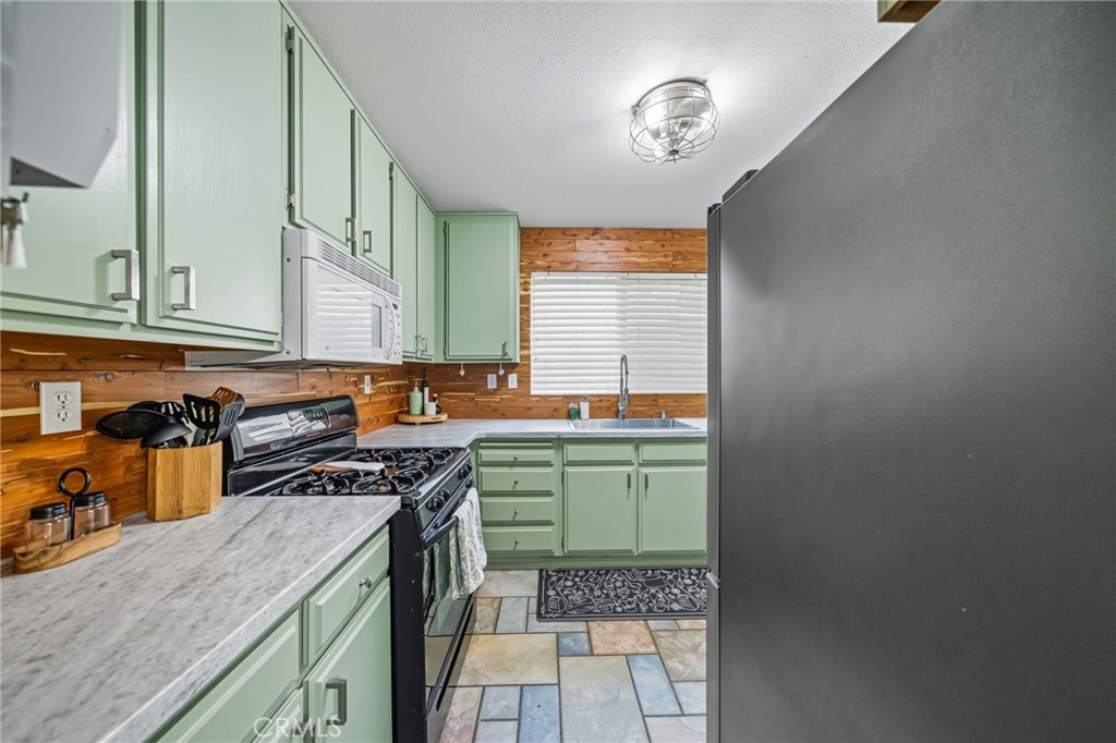 29787-29787 Berea Road Menifee, CA 92584 - Photo 16 of 45 a kitchen with a stove a sink and a cabinets