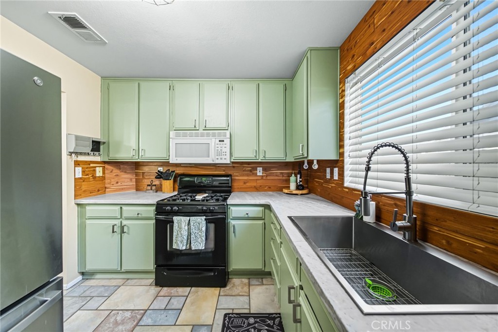 29787-29787 Berea Road Menifee, CA 92584 - Photo 20 of 45 a kitchen with a sink a stove and cabinets