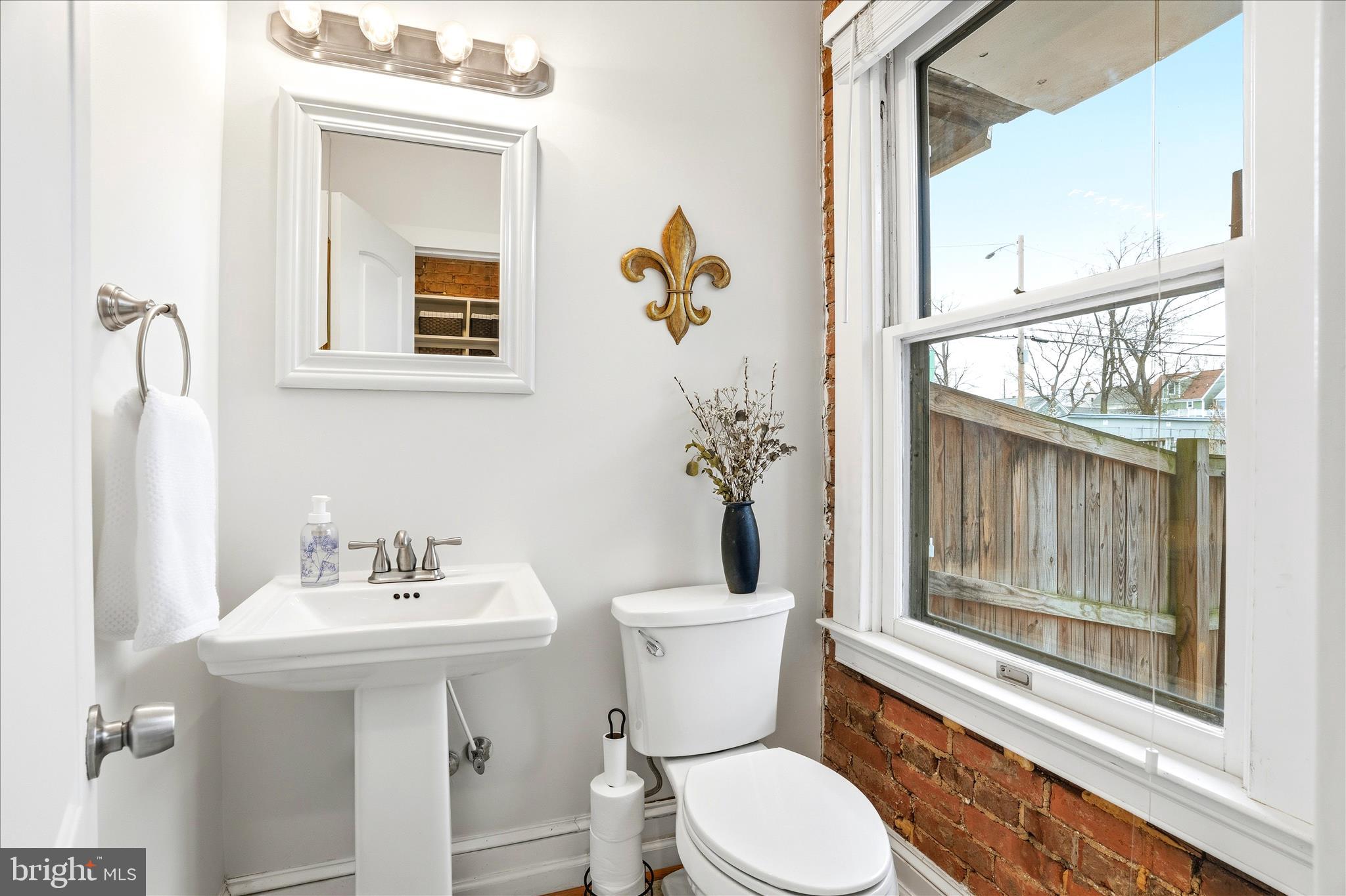 205 East 4th Street Frederick, MD 21701 - Photo 10 of 38 a bathroom with a toilet a sink and mirror