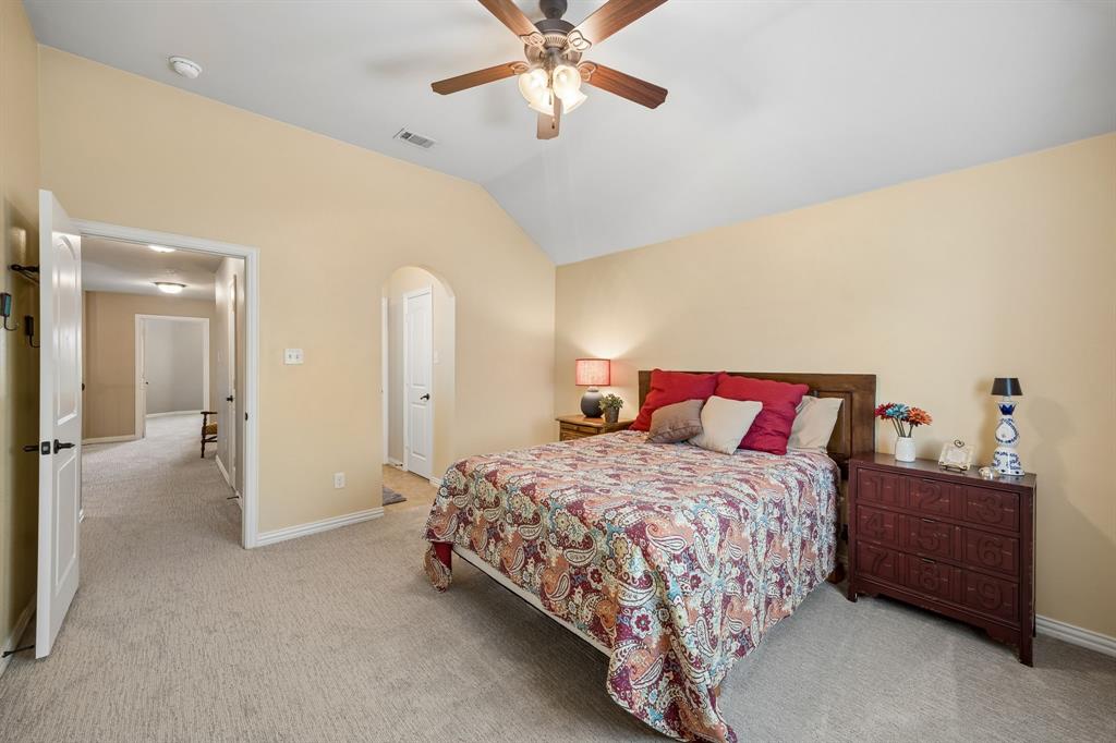 8104 Red Riv Run North Richland Hills, TX 76180 - Photo 26 of 38 a bedroom with a bed and a chandelier