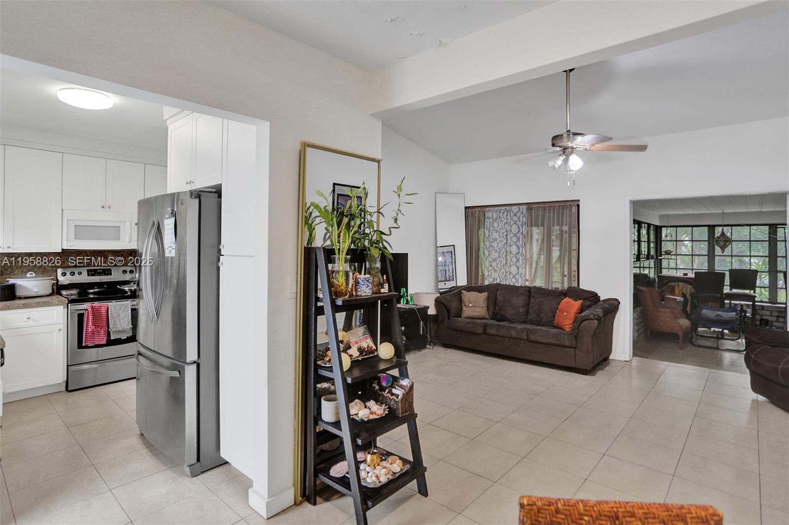 3255 Southwest 60th Avenue Miami, FL 33155 - Photo 22 of 42 a living room with stainless steel appliances furniture a chandelier and a kitchen view