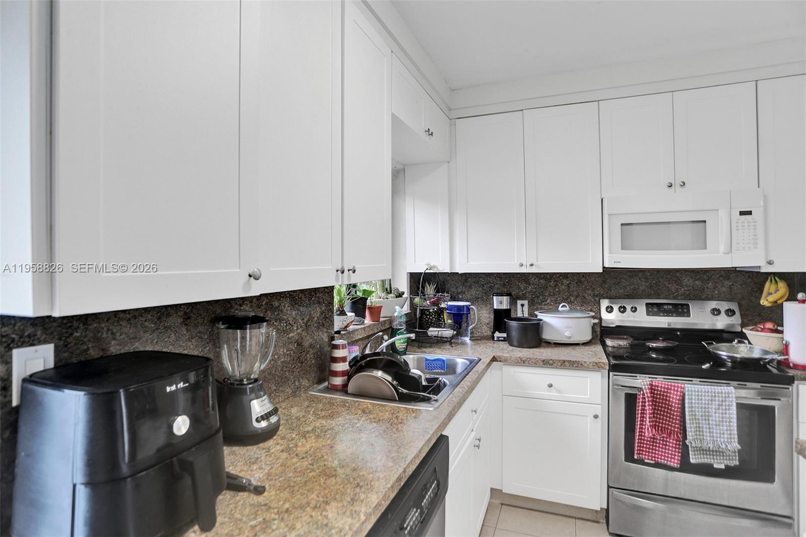 3255 Southwest 60th Avenue Miami, FL 33155 - Photo 23 of 42 a kitchen with a sink a stove and cabinets