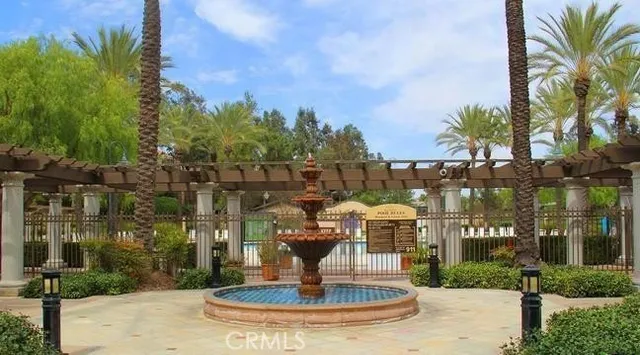 a view of swimming pool with outdoor seating and trees in the background