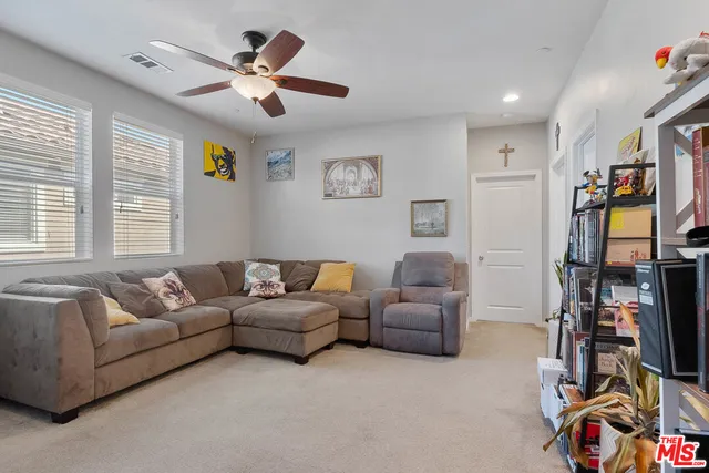 a living room with furniture ceiling fan and a window