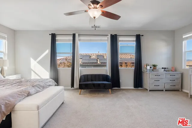 a bedroom with a bed and a chandelier fan