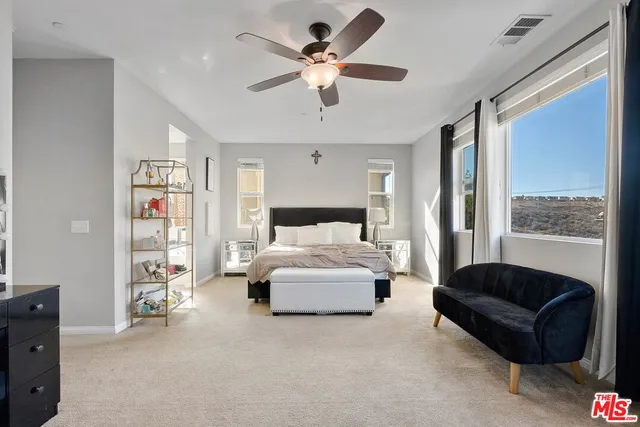 a spacious bedroom with a bed couch and window