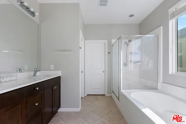 a bathroom with a tub a sink shower and mirror