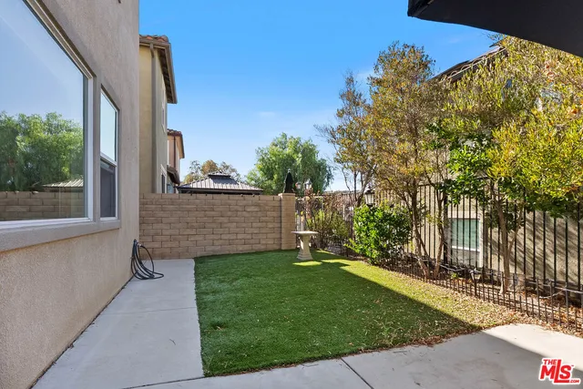 a view of a backyard with brick wall and a chair