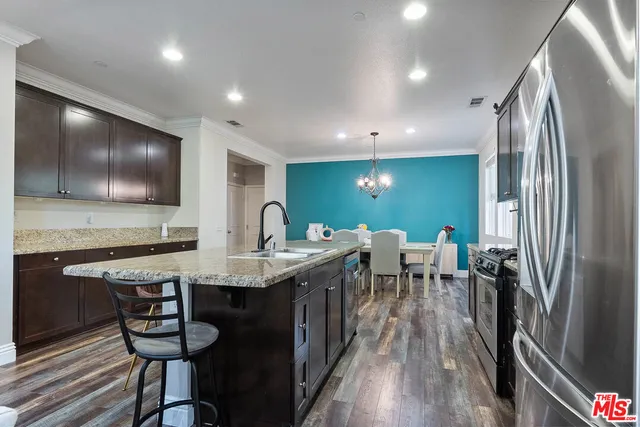 a kitchen with stainless steel appliances granite countertop a sink a stove and refrigerator