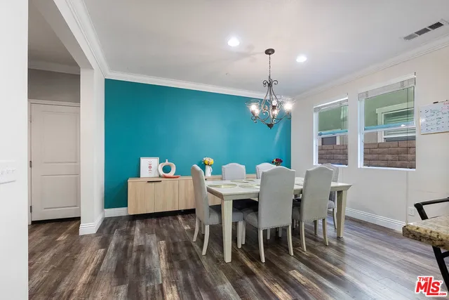 a dining room with furniture a chandelier and wooden floor