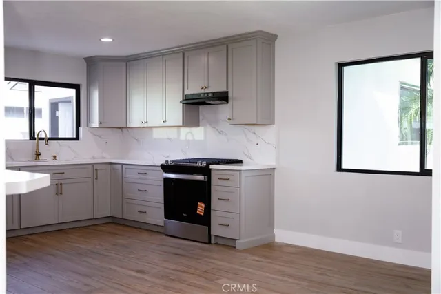 a kitchen with stainless steel appliances granite countertop a stove a sink and a microwave