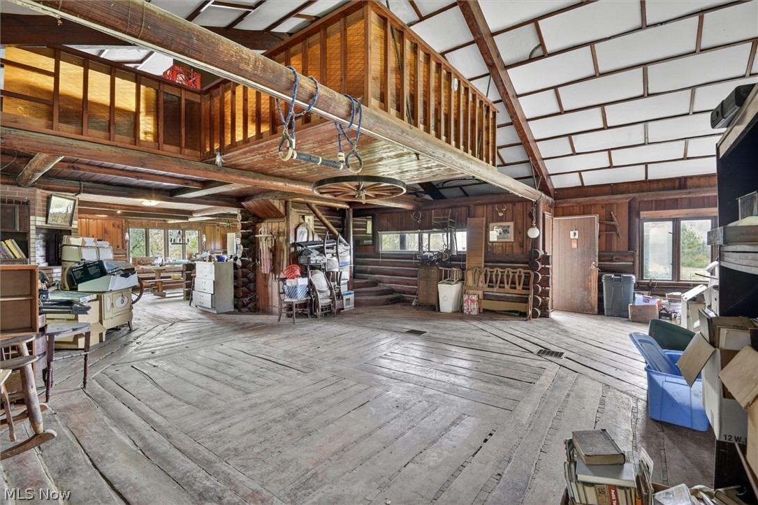 1526 Stevenson Road Ashtabula, OH 44004 - Photo 33 of 50 Spacious great room featuring vaulted ceilings with exposed beams, wood-finish flooring, and a second-story loft with wood railings