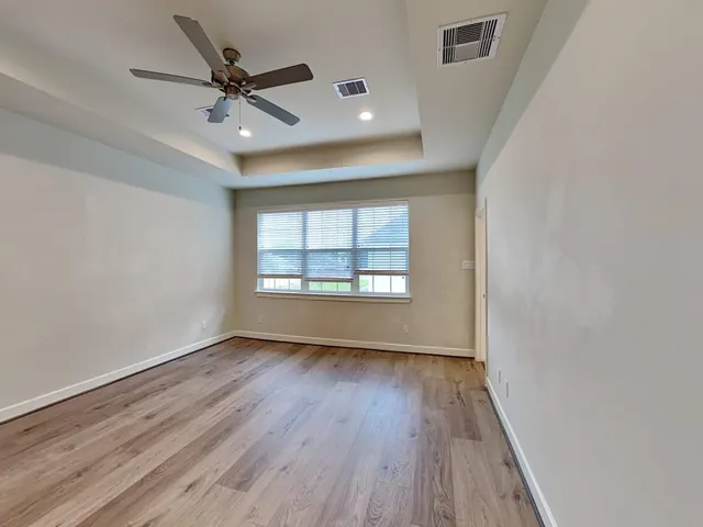 a view of empty room with wooden floor
