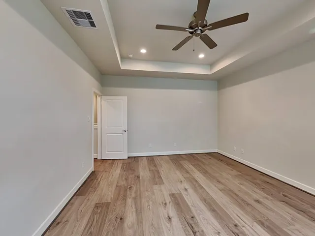 an empty room with windows and fan