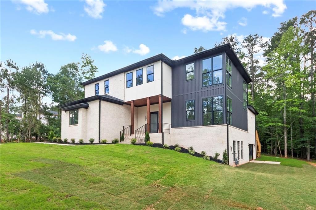 7066 Bells Way Fairburn, GA 30213 - Photo 2 of 64 a view of a white house with a big yard and large trees