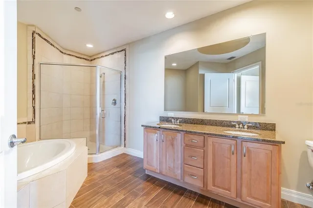 a bathroom with a granite countertop toilet sink and mirror