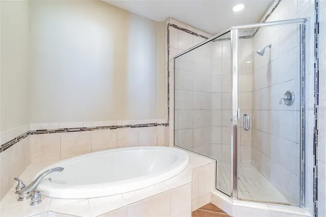 a bathroom with a granite countertop sink a mirror a bathtub and shower