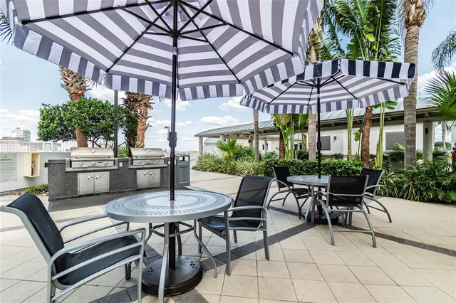 a patio with a table and chairs under an umbrella