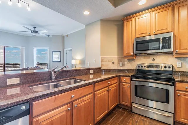 a kitchen with stainless steel appliances granite countertop a stove a sink and a refrigerator