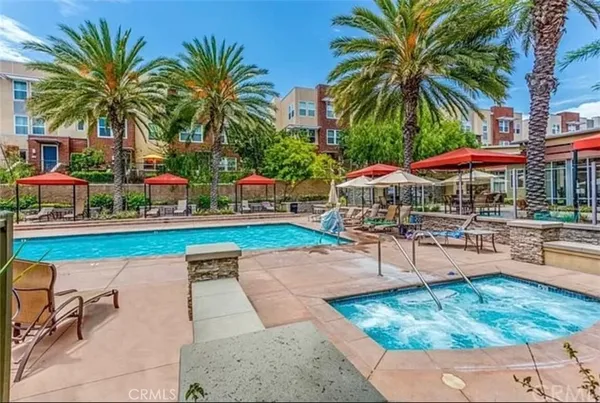 a view of a swimming pool with a patio and palm trees