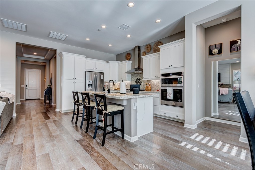 11137 Briar Rose Court Corona, CA 92883 - Photo 24 of 75 a kitchen with white cabinets and chairs