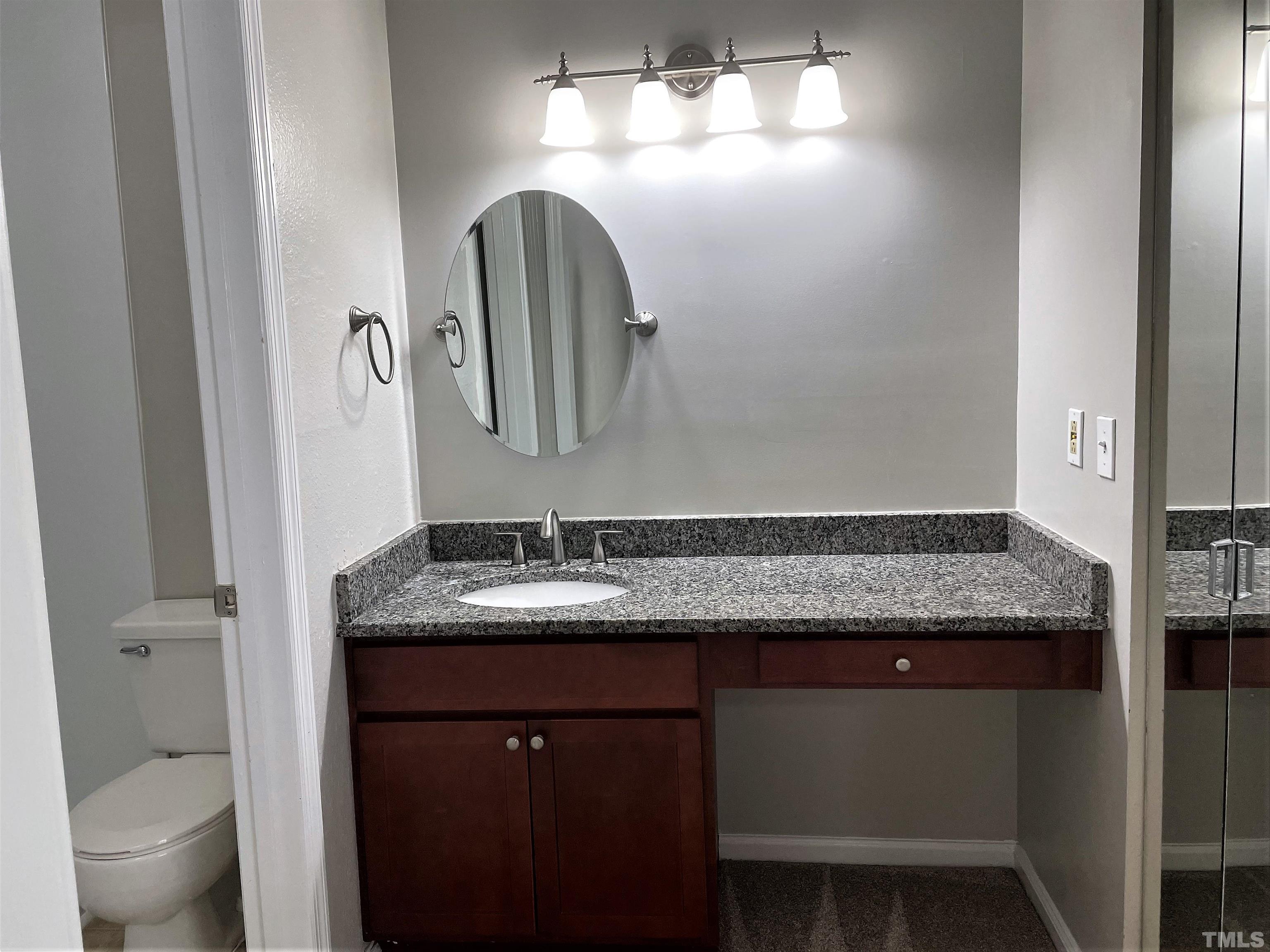 2416 Condor Court Raleigh, NC 27615 - Photo 18 of 28 a bathroom with a granite countertop sink and a mirror