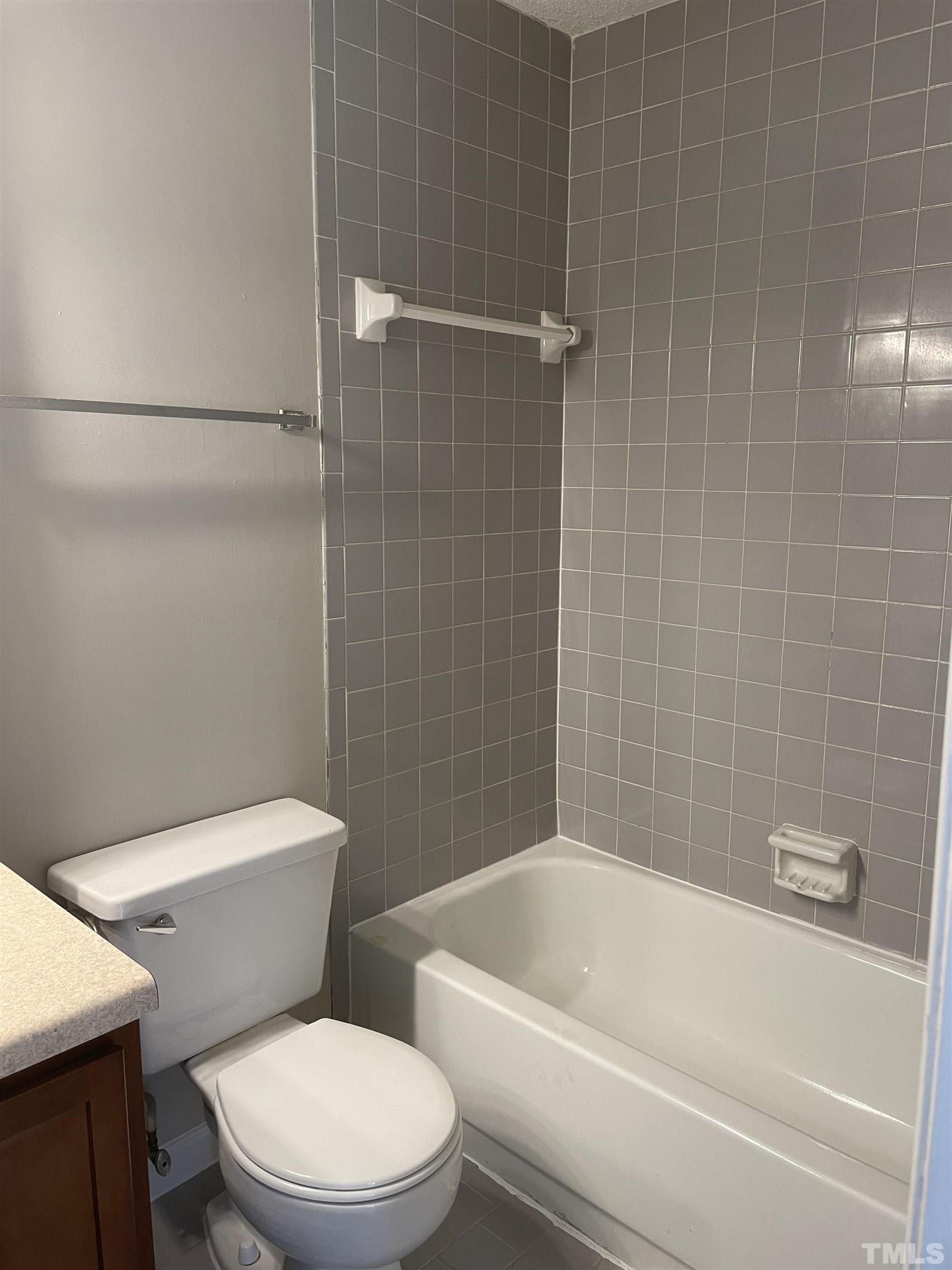 2416 Condor Court Raleigh, NC 27615 - Photo 25 of 28 a white toilet and tub sitting next to a bathroom sink