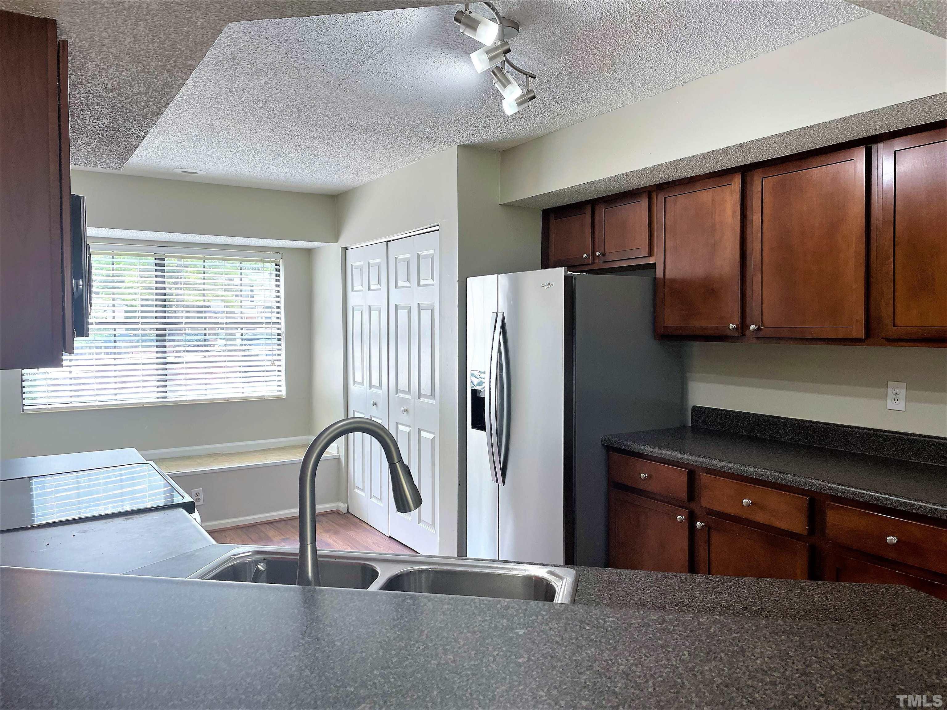 2416 Condor Court Raleigh, NC 27615 - Photo 5 of 28 a kitchen with stainless steel appliances granite countertop a refrigerator and a stove top oven