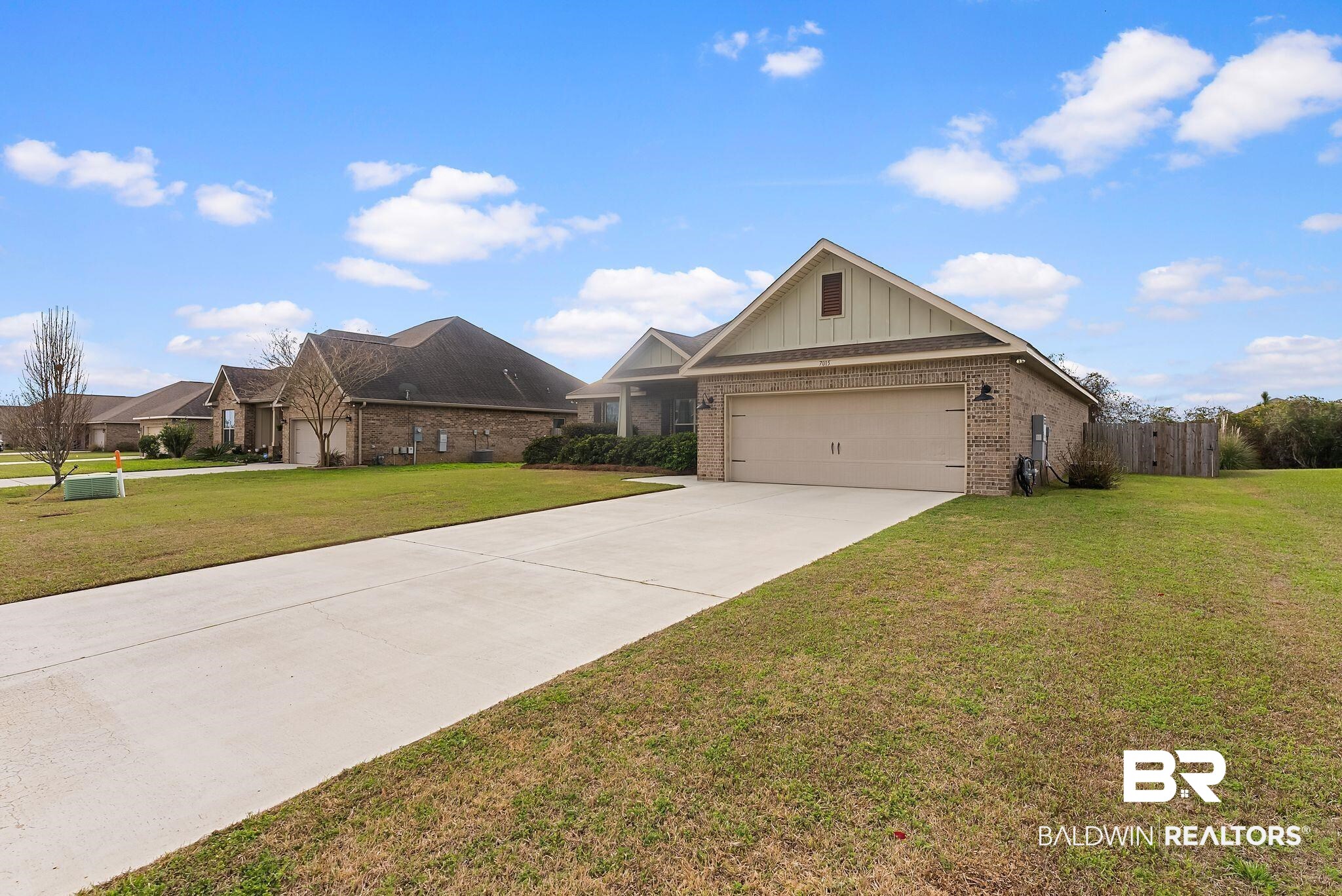 7015 Rocky Rd Loop Gulf Shores, AL 36542 - Photo 3 of 41 View of front facade featuring brick siding, driveway, a garage, and board and batten siding