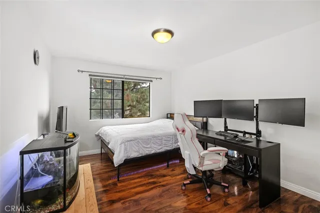 a bedroom with a bed and wooden floor