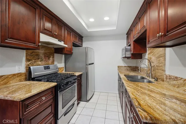 a kitchen with stainless steel appliances granite countertop a stove a refrigerator and a sink